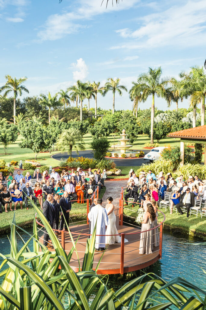 Bride and groom exchange vows above the water at the stunning Longan’s Place in Miami, Florida.